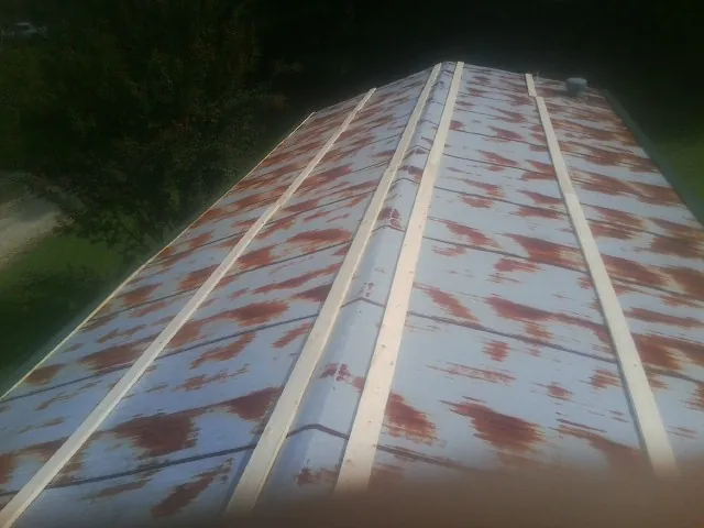 Rusted metal roof panels with new wood purlins before replacement — Storm Damage Roof Repair in The Plains by Roofing Brothers