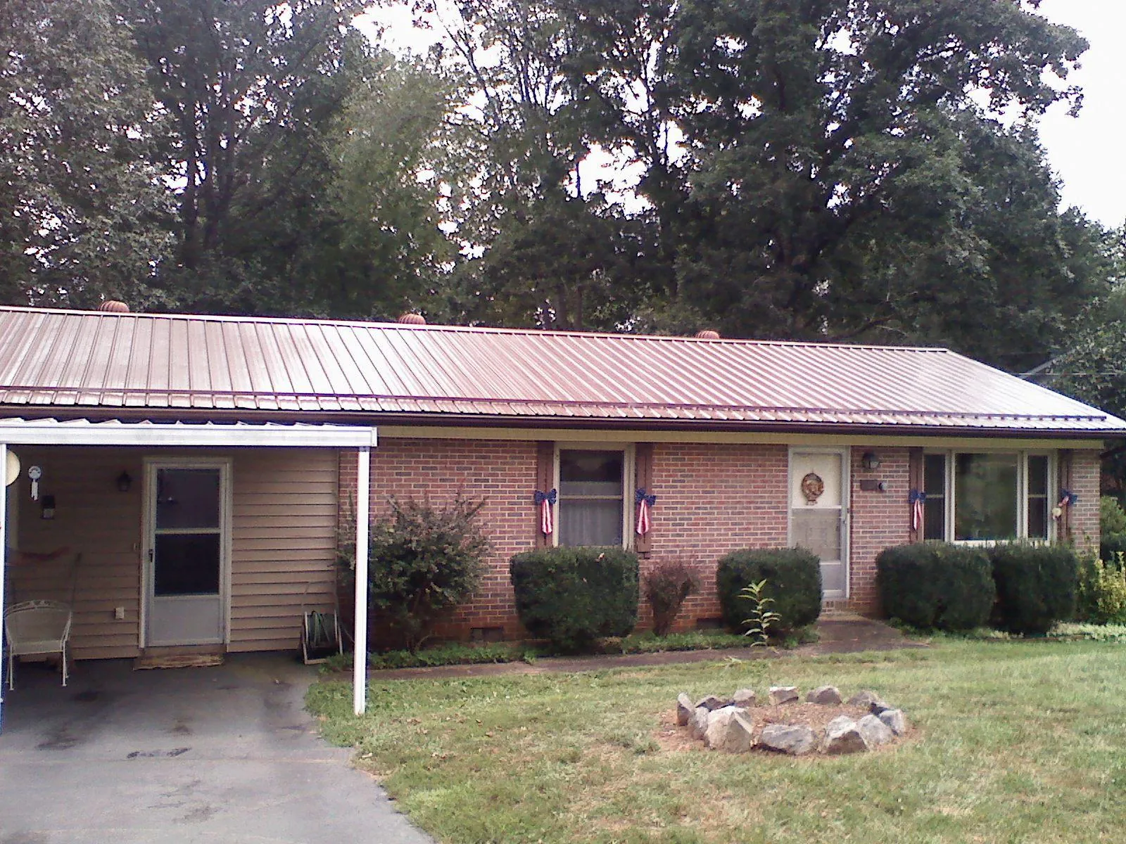 Bronze metal roof and carport on a brick ranch home — Roof Repair work by our crew in The Plains